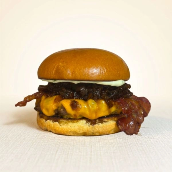 Hambúrguer Anfield com pão artesanal, queijo cheddar, bacon crocante e cebola caramelizada